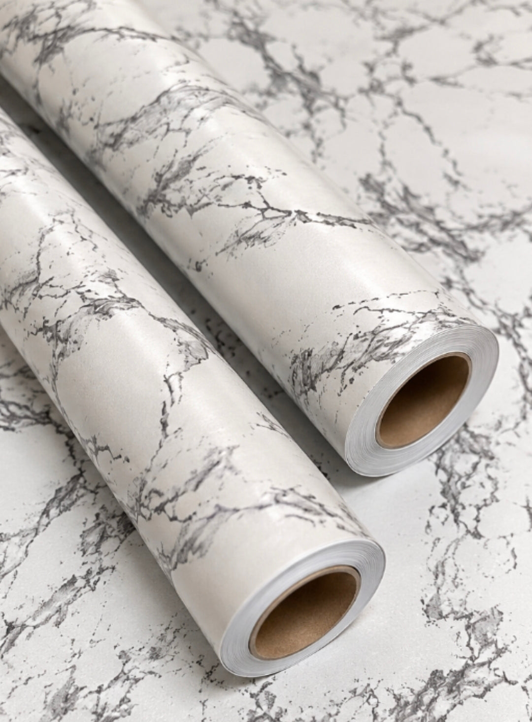 White marble pattern on two large rolls of wallpaper from Budget Interiors, showcasing elegant marble design and smooth texture.