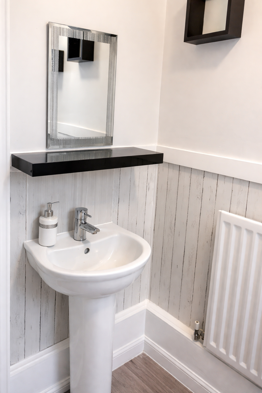White wood effect self-adhesive roll by Budget Interiors, showcasing a textured wood pattern on a flexible surface.