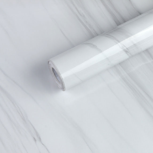 White marble slab by Budget Interiors with natural veining and polished surface, ideal for countertops or decorative accents.